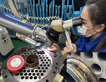 DSI technician inspecting a welded component under a microscope